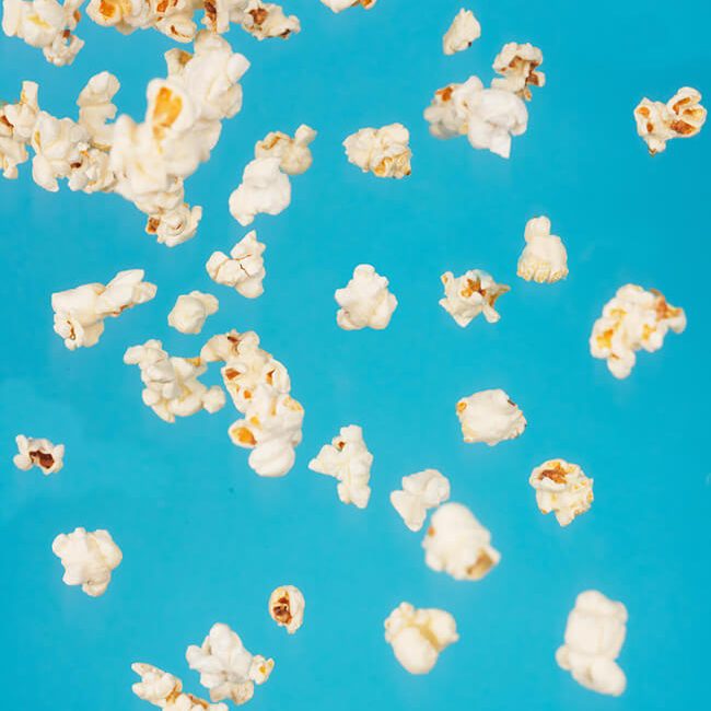 Popcorn vor blauem Hintergrund - Filmcatering wird mit Herr Ribisel zum Genuss